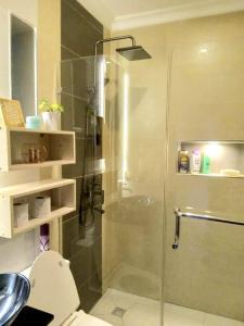 a bathroom with a glass shower with a toilet at Spacious, Scenic & Homely Loft in Kigali