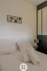 Un dormitorio con una cama blanca con una foto en la pared en R'Apparts T2 Vercors Horizon, en Meylan