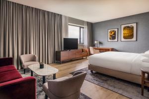 ジュネーヴにあるGeneva Marriott Hotelのベッドとテレビ付きのホテルルーム