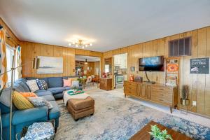 a living room with a blue couch and a tv at Bitely Cottage Rental Fire Pit and Beach! in Bitely
