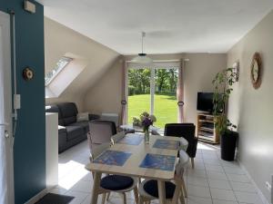 a living room with a table and a couch at La petite maison in Quemper-Guézennec