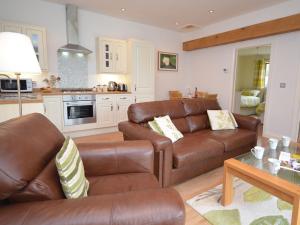 a living room with a leather couch and a table at 2 Bed in Bath CHELA in Stowey