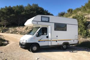 a white camper truck parked on a dirt road at Akisol Azeitão Ride in Azeitao
