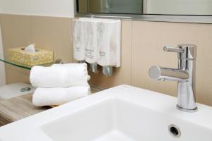 a bathroom sink with towels hanging on the wall at Cairns Central Plaza Apartment Hotel in Cairns