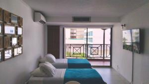 a bedroom with two beds and a balcony at Apartamento Premier 6 En el edificio Hansa Reef Club in San Andrés