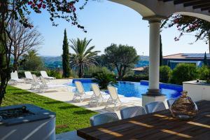 un grupo de sillas blancas y una piscina en Villa Algarve, en Vila Nova de Cacela