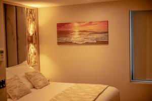 伯明罕的住宿－Hotel Holloway，卧室配有一张床,墙上挂有绘画作品