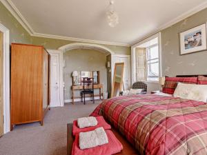 a bedroom with a large bed and a table at 3 Bed in Kinglassie FF224 in Kinglassie