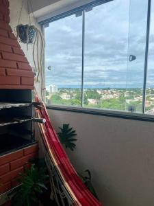 a room with a hammock in front of a window at Apartamento decorado no Jardim Lancaster in Foz do Iguaçu