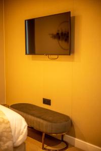 een kamer met een tv aan een gele muur bij Hotel Holloway in Birmingham