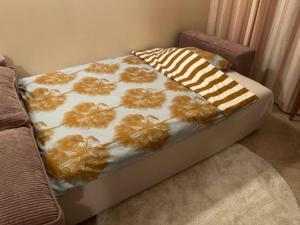 a bed with a floral comforter on top of it at Apartment Golden Sands and Black Sea, Varna in Golden Sands
