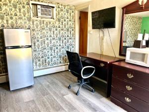 um quarto com uma secretária, uma cadeira e um frigorífico em Travelers Inn Olney em Olney