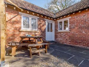 a patio with a table and benches in front of a brick building at 2 Bed in Thornton le Dale 27112 in Allerston