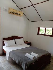 a bedroom with a bed with two towels on it at Cabañas Don Rafa Santa Marta in Santa Marta