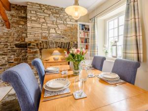 een eetkamer met een tafel en stoelen en een stenen muur bij 2 bed in Appledore TRQCT in Appledore