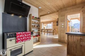 a kitchen with a stove and a tv on the wall at Chalet Le Gypaète in Le Grand-Bornand