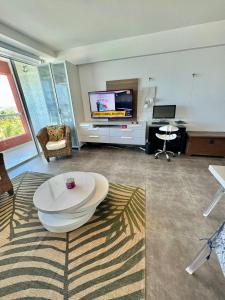 sala de estar con mesa y TV en Cimarron Suites Playa Parguito, en El Cardón