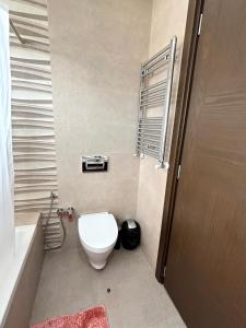 a bathroom with a toilet and a sink and a tub at Abilia Appart - À Proximité de l'Aéroport - Confort et Élégance in Sukrah