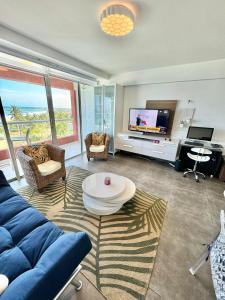 un soggiorno con divano blu e TV di Cimarron Suites Playa Parguito a El Cardón