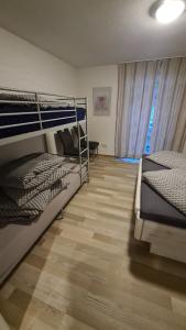 a bedroom with two bunk beds and a wooden floor at Apartament Berghof in Bayerischen Wald in Sankt Englmar