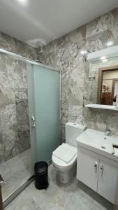a bathroom with a toilet and a sink and a mirror at Golden Tulip Suite Apart in Istanbul