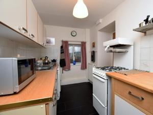 una cucina con elettrodomestici bianchi e piano di lavoro in legno di 2 bed in Chapel-en-le-Frith PK346 a Chapel-en-le-Frith