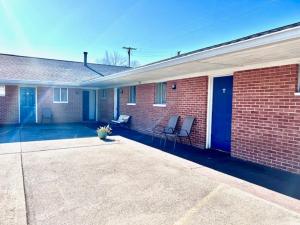 un edificio de ladrillo con 2 sillas en un patio en Travelers Inn Olney, en Olney