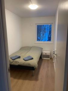 a small bedroom with a bed and a window at Ivar and Sofies House in Tromsø