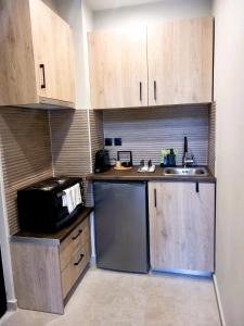 a small kitchen with wooden cabinets and a sink at athilia in Nikiana