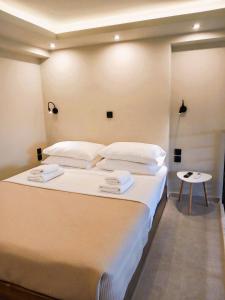 um quarto com uma cama grande com lençóis brancos e almofadas em athilia em Nikiana