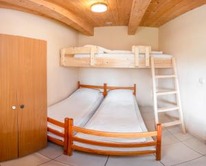 two bunk beds in a room with a ladder at Domki Ajna Park w uzdrowisku in Kołobrzeg