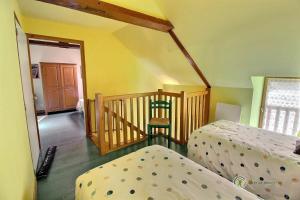 Zimmer mit 2 Betten und einer Treppe mit einem Stuhl in der Unterkunft Tournesol in Saint-Gildas