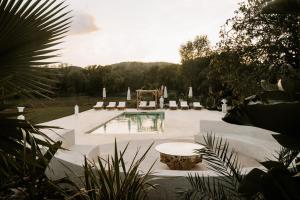 een zwembad met stoelen en een tafel in de tuin bij Le Mas Montserrat in Le Luc