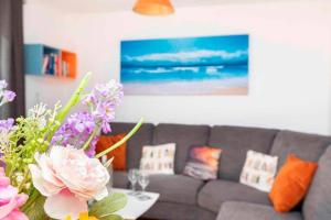 a living room with a couch and a table with flowers at BOURNECOAST- NEAR TOWN CENTRE and BEACH with BEACH HUT - FM6114 in Bournemouth