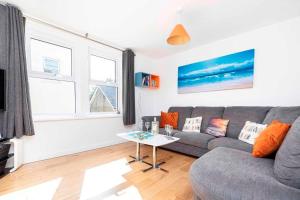 a living room with a gray couch and a table at BOURNECOAST- NEAR TOWN CENTRE and BEACH with BEACH HUT - FM6114 in Bournemouth