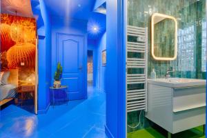 a blue bathroom with a sink and a mirror at Luxury Jardin Majorelle paris orly avec jacuzzi in Vigneux-sur-Seine