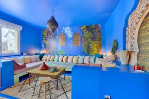 a living room with blue walls and a couch at Luxury Jardin Majorelle paris orly avec jacuzzi in Vigneux-sur-Seine