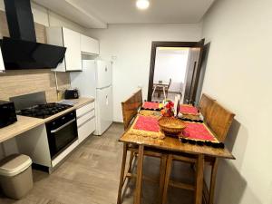 eine kleine Küche mit einem Tisch und einem Herd in der Unterkunft Abilia Suite - À Proximité de l'Aéroport - Confort et Élégance in La Soukra + 20 Fotos