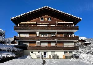 un grand bâtiment avec de la neige devant lui dans l'établissement Chalet Ribi, à Grindelwald