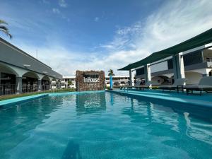 a large swimming pool in a resort with chairs at InHouse Obregón in Ciudad Obregón