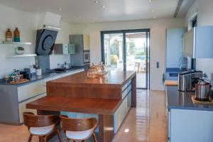 Villa Algarve في فيلا نوفا دي كاسيلا: مطبخ مع كونتر خشبي وكراسي فيه