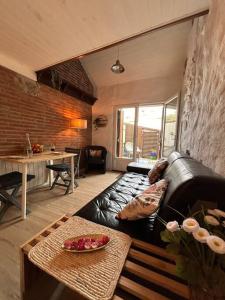 uma sala de estar com um sofá de couro preto e uma mesa em Charmant duplex 2 chambres/terrasse em Prades