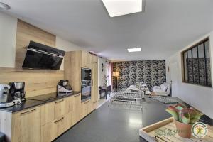 eine Küche mit Holzschränken und ein Wohnzimmer in der Unterkunft Maison de la ville-j in Plénée-Jugon