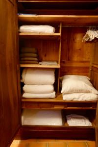 a closet filled with white towels and pillows at CHARMANTE MAISON A SAINT GUILHEM LE DESERT in Saint-Guilhem-le-Désert
