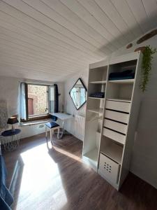 um quarto com uma prateleira de livros brancos e uma janela em Charmant duplex 2 chambres/terrasse em Prades
