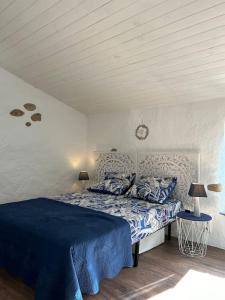 プラードにあるCharmant duplex 2 chambres/terrasseのベッドルーム1室(青いシーツと枕のベッド1台付)