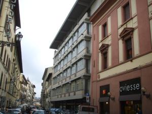 una strada cittadina con auto parcheggiate sulla strada di Sette Angeli Rooms a Firenze