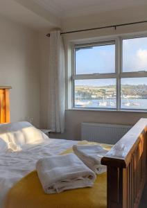 a bedroom with a bed with towels on it at Luxury Waterfront House in Cobh