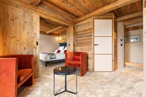 Habitación con paredes de madera y dormitorio con cama. en Hotel Le Chabichou, en Courchevel