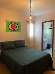 um quarto com uma cama com um edredão verde em neighbor.HUB hostel & coliving FLORIPA em Florianópolis